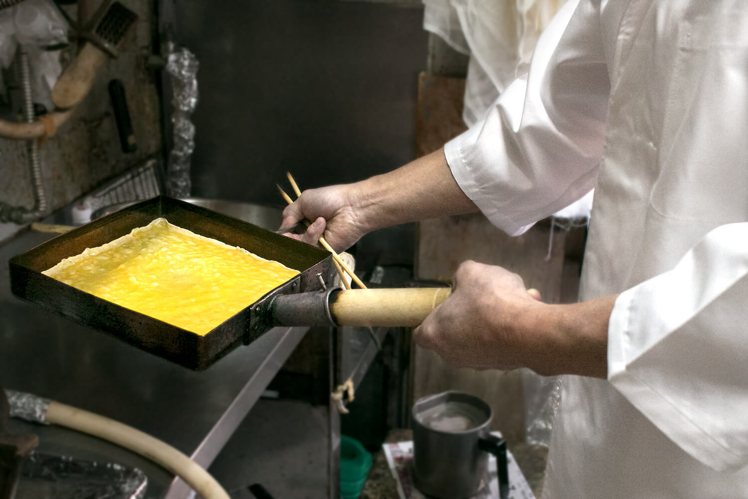 玉子焼き器を傾けて、卵液を全体に均一になるように伸ばします
