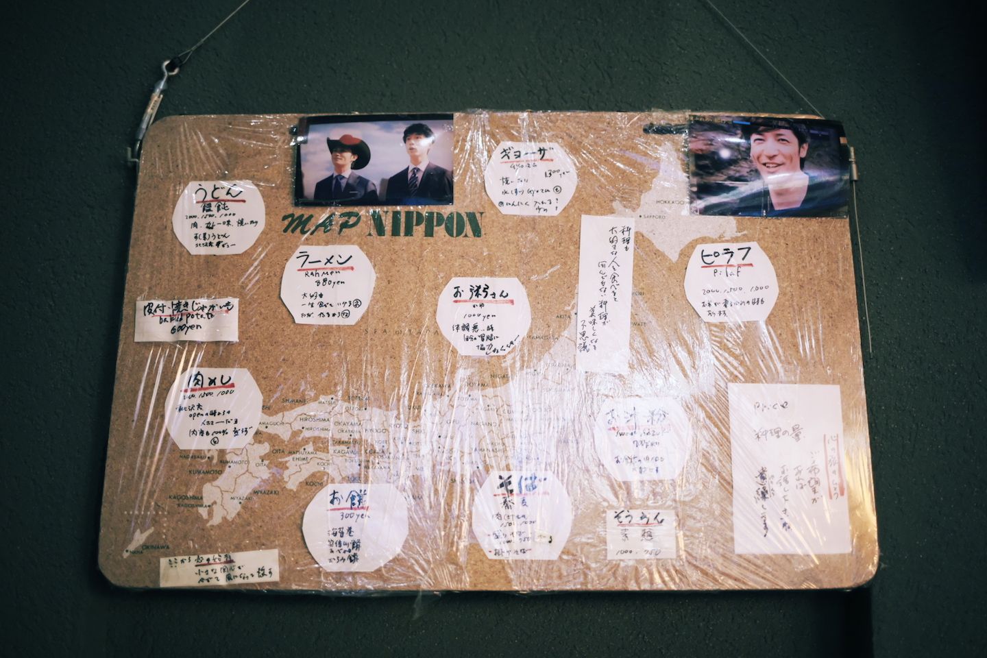 なぜか日本地図が描かれたコルクボードに、手書きのメニューを書いた紙を貼っている