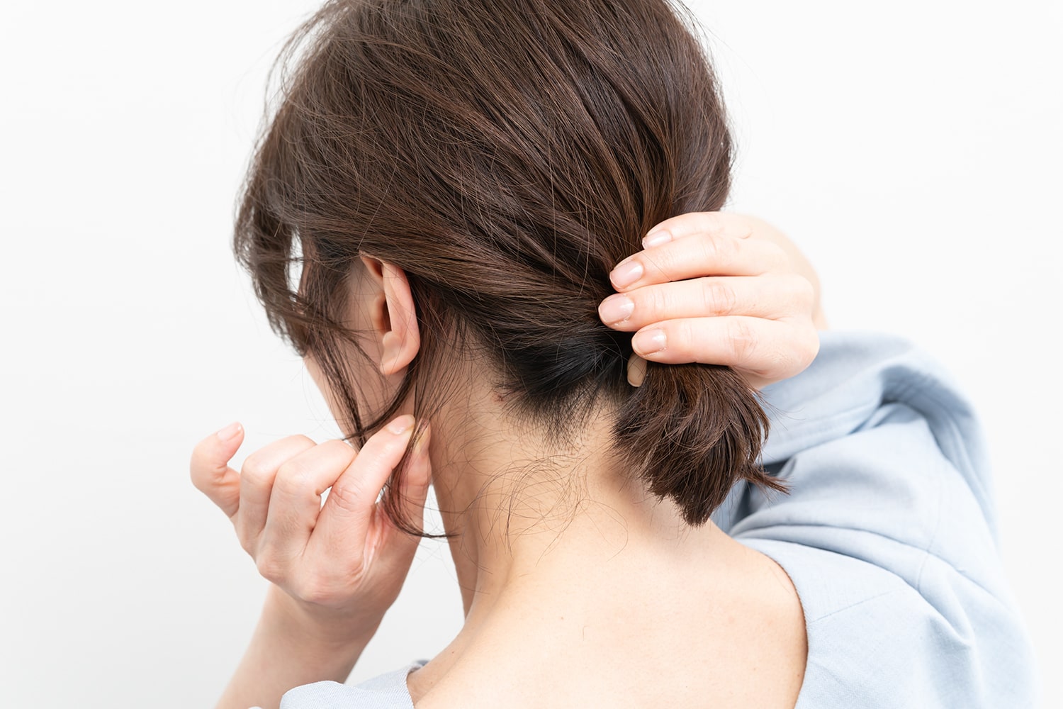 結んだ毛束を抑えながら、耳裏、襟足を少しずつつまんで引き出す。生え際に沿って引き出していくと綺麗にまとまる