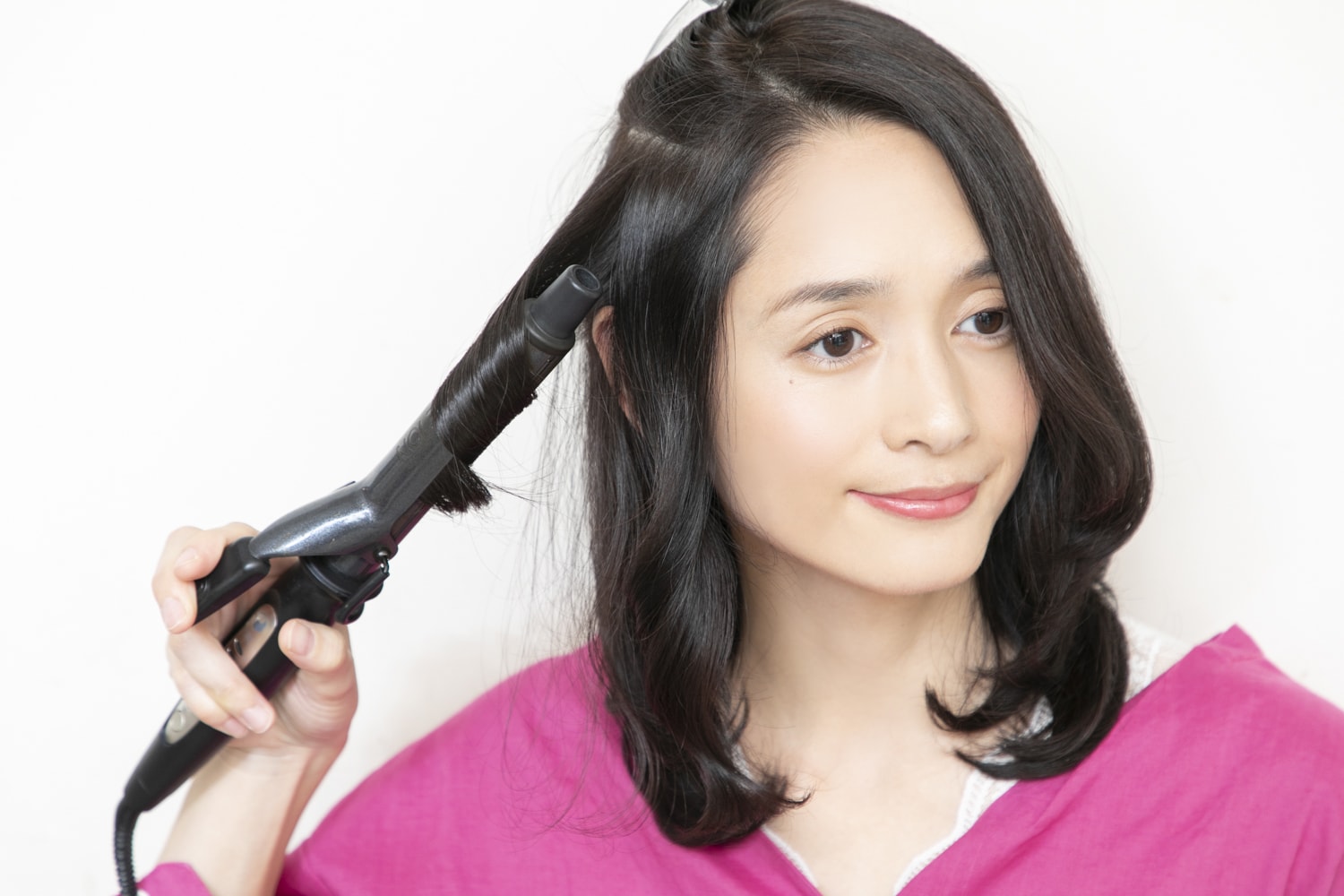 26mmのヘアアイロンを使用。トップの髪を外し、顔近くから外向き→内向き→外向きの順に1回転巻いていく。