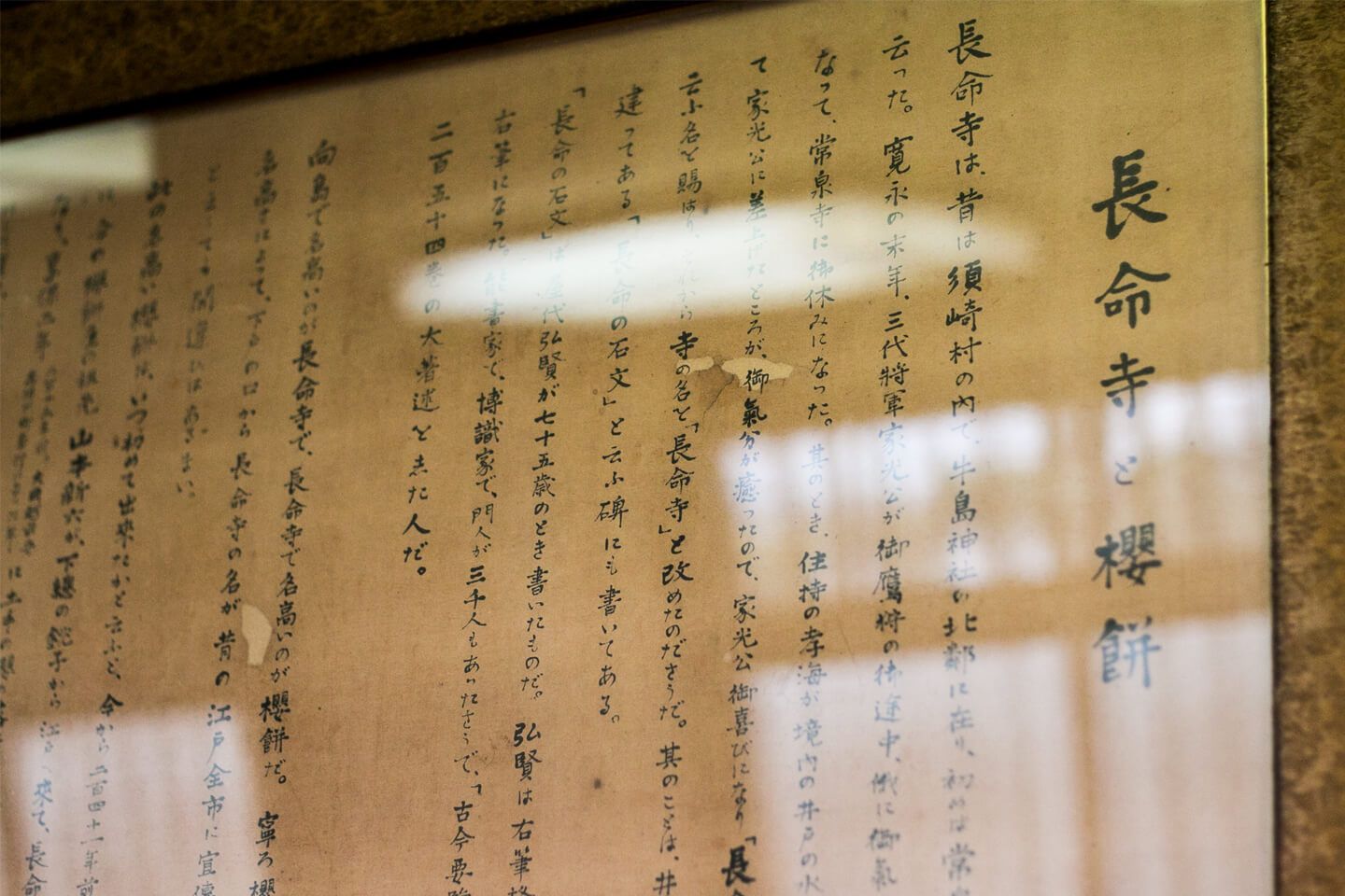 「長命寺と桜餅」の題がついた文章が筆で記された紙が額に入り壁にかけられている